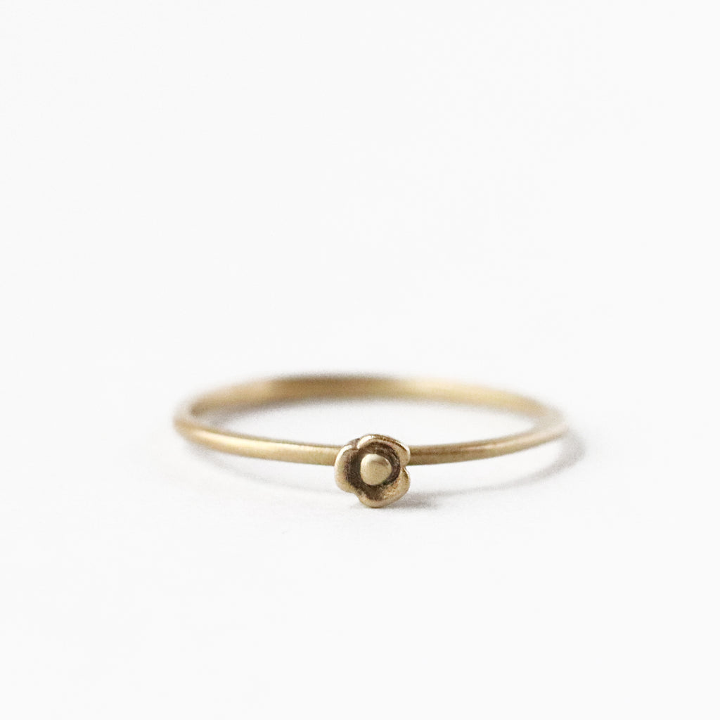 The tiny three petaled blossom sometimes known as Purple Queen, is perfect rendered into this solid 10k yellow gold ring. Wear it on its own or as part of a stack. 