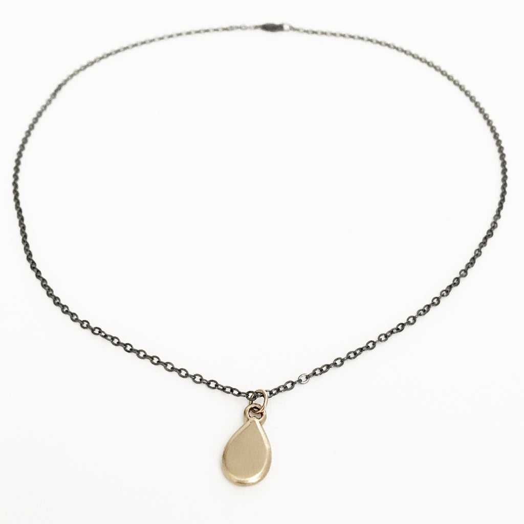 Small (but weighty) solid 10k gold teardrop charm. Simple and feminine, but with a minimalist aesthetic.  Hand carved, cast and finished in NY. Solid 10k yellow gold with 18